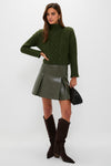 Model wearing Olive Cable Knit Cropped Perry Turtleneck, paired with an A-line mini skirt, showcasing a classic, effortless, and fun high-end style.