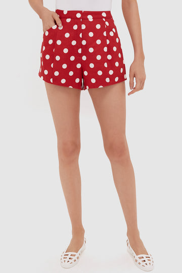A person wears POSSE high-waisted red polka dot linen shorts, a white top, and white flat shoes for a playful, stylish look.