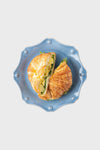 Chambray Berry & Thread Scalloped Dessert/Salad Plate elegantly displays a buttery croissant filled with creamy eggs and greens, offering a classic, high-end, and effortless dining experience.