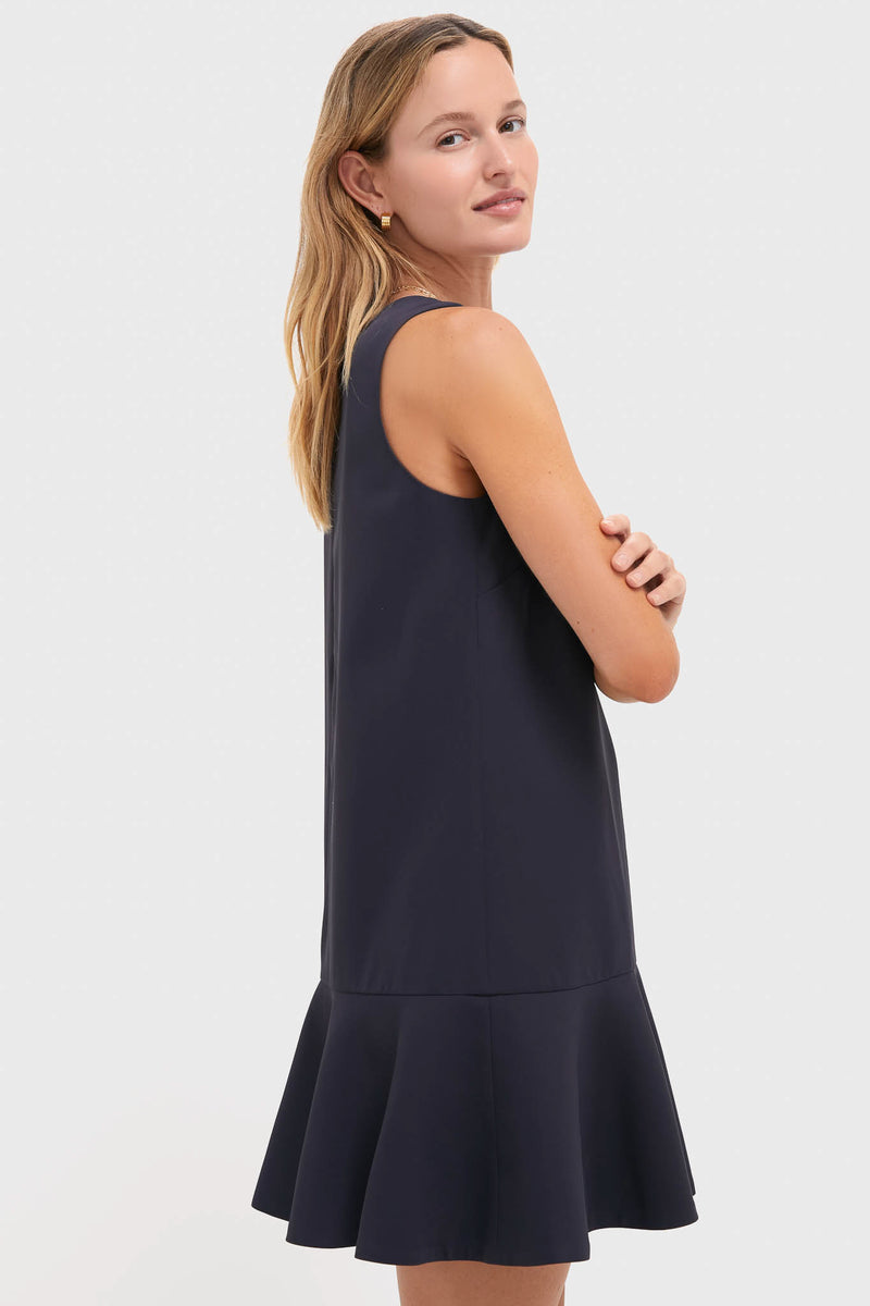 Model in a classic, sleeveless Dark Slate Navy Flutter McKinney Mini Dress, showcasing its effortless swing silhouette and flutter hem for a fun, high-end look.