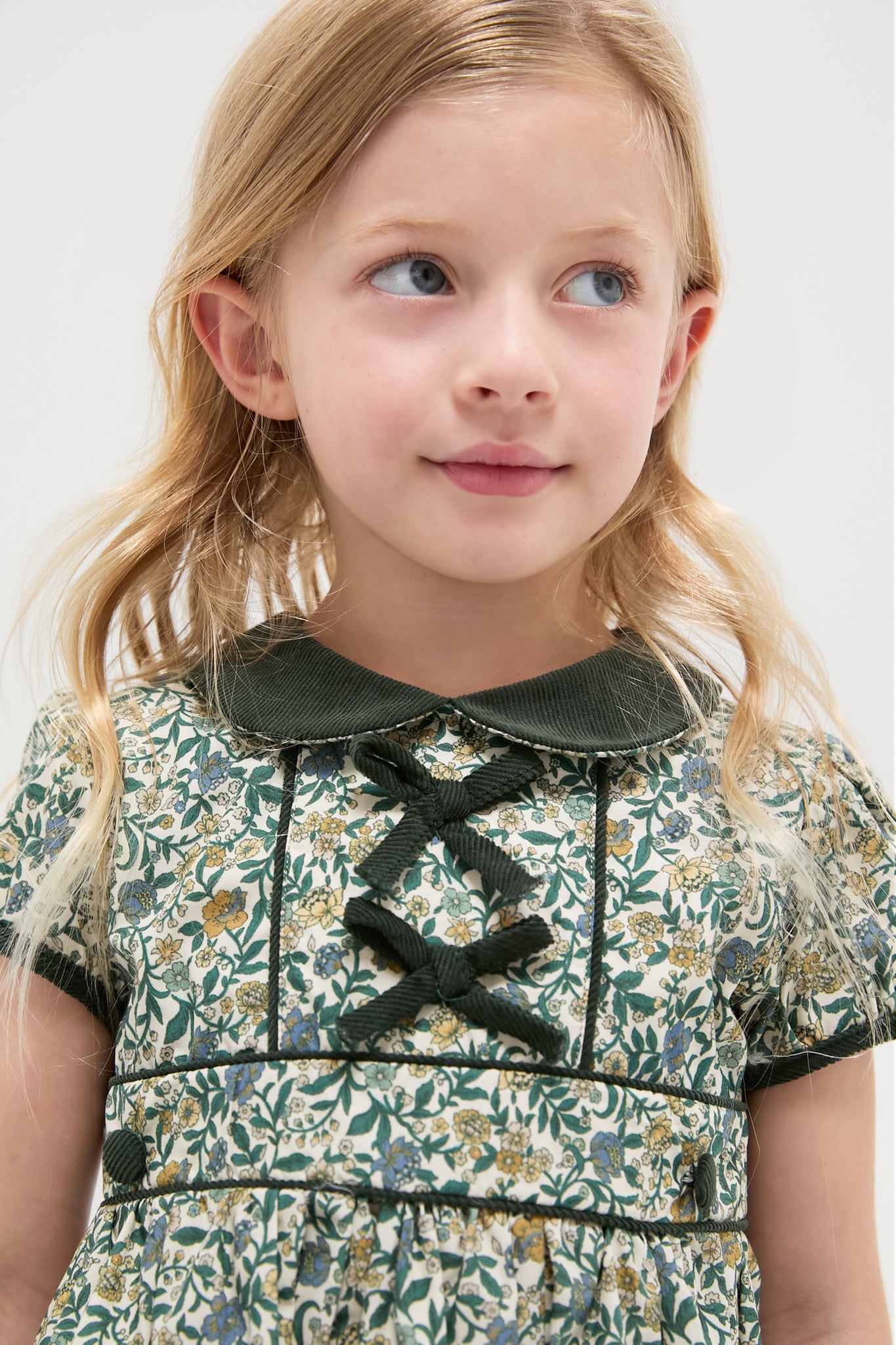 Classic and effortless, the Bottle Green Floral Portia Girl Dress features a fit-and-flare silhouette with Peter Pan collar and decorative bows, perfect for high-end, fun occasions.