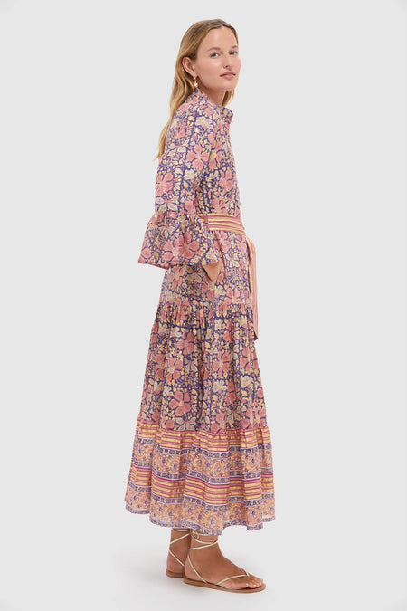 Model in profile wearing the Matera Navy Ruffle Collar Bell Maxi Dress with floral print, showcasing an effortless, classic silhouette with a tiered skirt and self-tie belt.