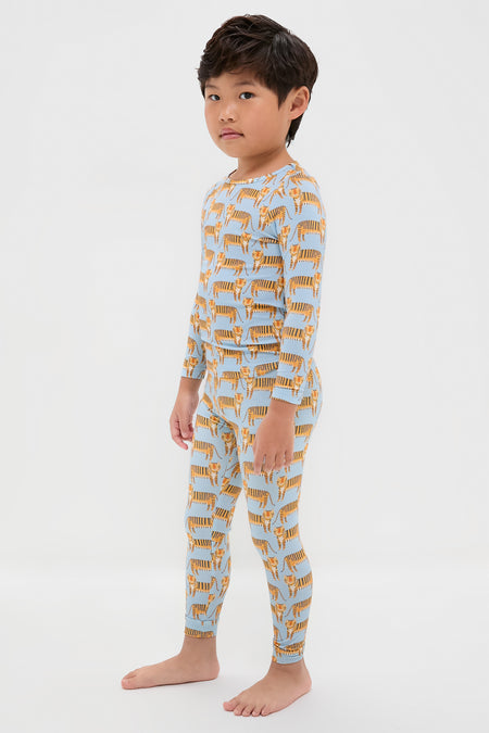 Young boy in classic, effortless Tigers Kids Bamboo Pj Set, featuring fun tiger prints on a light-blue top and leggings. High-end, breathable bamboo fabric ensures comfort.