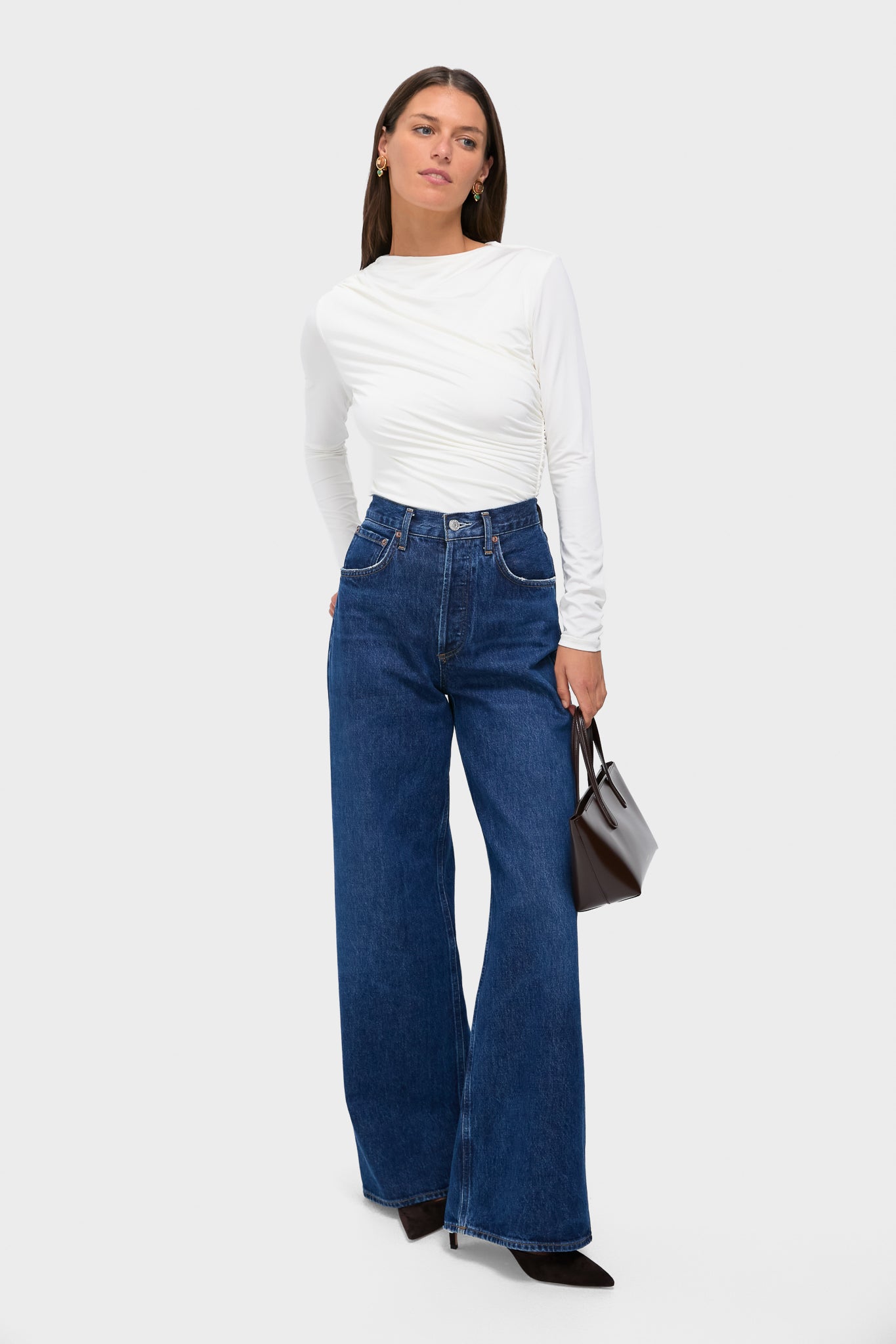 Model showcases classic, effortless style with Oak and Green Earrings, featuring chic oak and green stones in gold-plating, paired with high-end outfit including white top and wide-leg jeans.