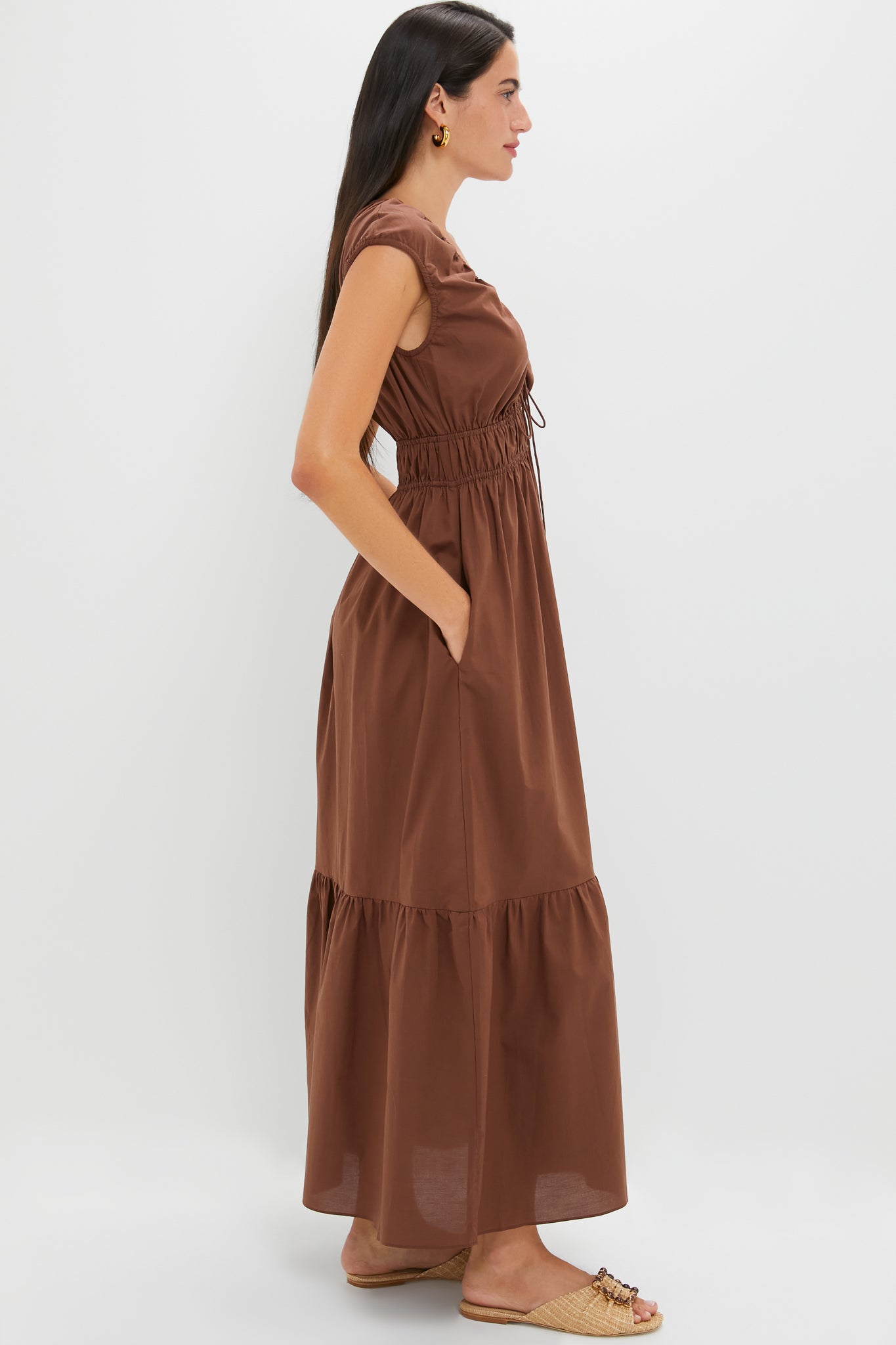 Chestnut Brown Hedda Maxi Dress: A classic, effortless silhouette featuring a tiered skirt, elasticized waist, and drawstring V-neck, paired with chic sandals for a high-end, fun look.