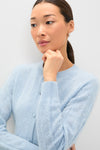 Woman wearing the classic Light Blue Brushed Merino Wool Macy Cardigan, showcasing an effortless and high-end style. Her contemplative gaze adds a fun, sophisticated touch.