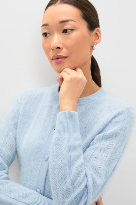 Woman wearing the classic Light Blue Brushed Merino Wool Macy Cardigan, showcasing an effortless and high-end style. Her contemplative gaze adds a fun, sophisticated touch.