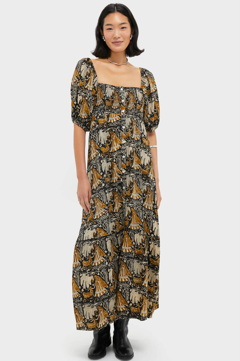 Model wearing the Story Print Santiago 3 Maxi Dress, featuring a classic tiered design with folkloric motifs, square neckline, and puff sleeves. Effortless, high-end autumnal style with fun, artistic flair.
