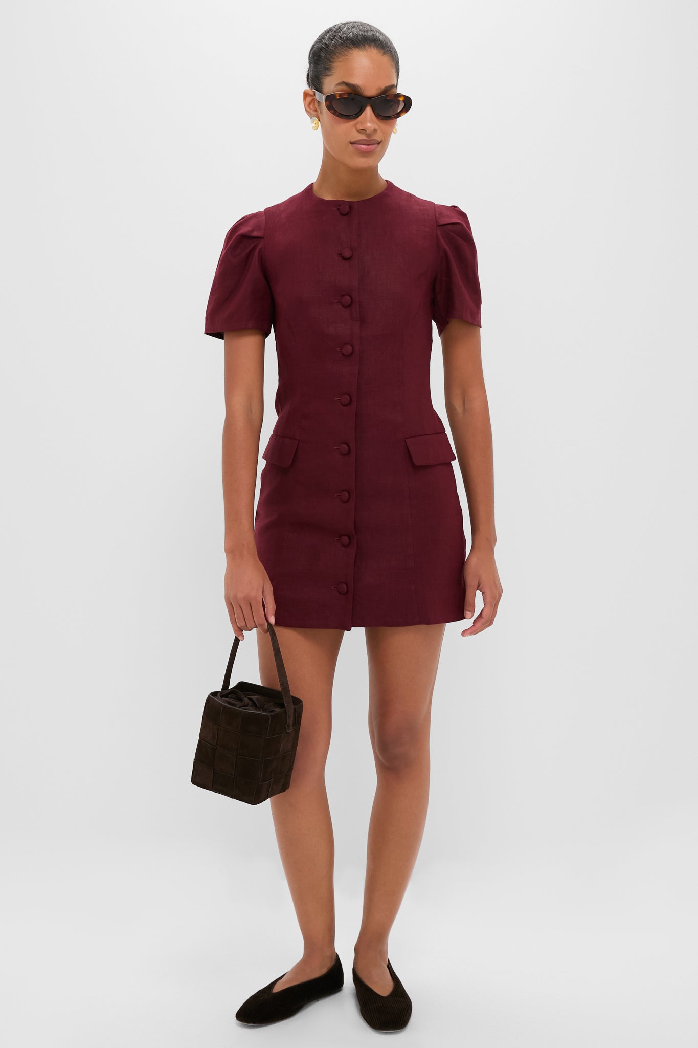 Woman holding the classic Woven Tmoro Suede Laith Top Handle Bag, an effortless high-end accessory with a rich espresso weave and drawstring closure, embodying fun sophistication.