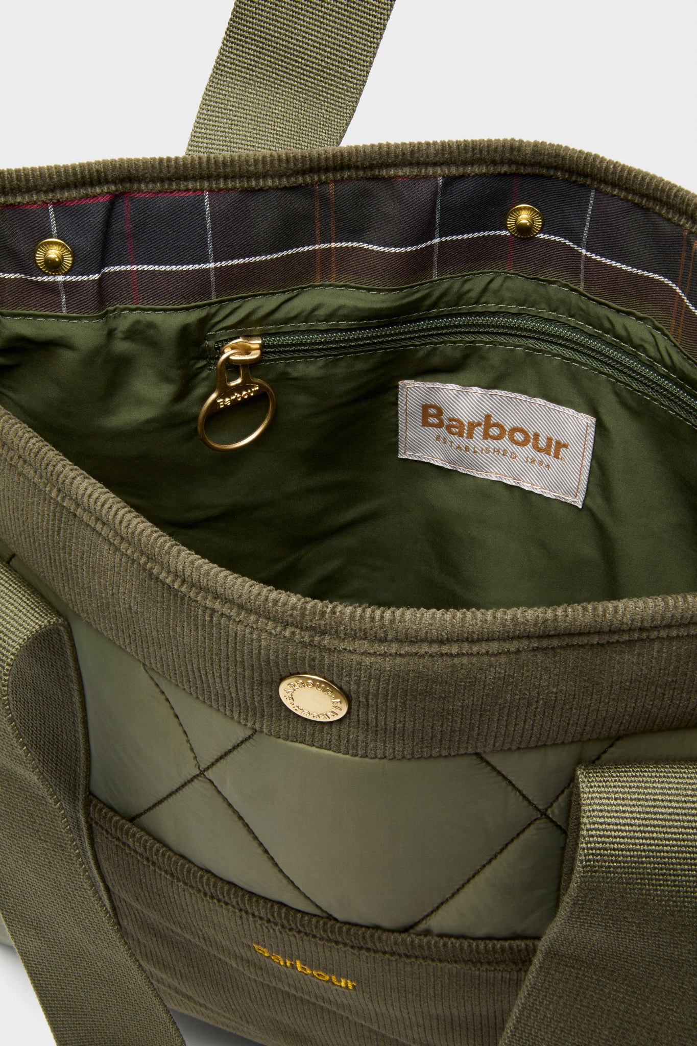Olive Healy Tote Bag, classic and fun with quilted design, tartan-lined interior, snap closure, and webbing handles, embodies effortless high-end style and functionality.