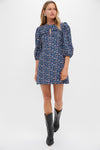 Woman in a classic Black & Navy Corduroy Floral Keyhole Moore Mini Dress, effortlessly styled with mid-calf cowboy boots and statement earrings, exuding fun and high-end charm.