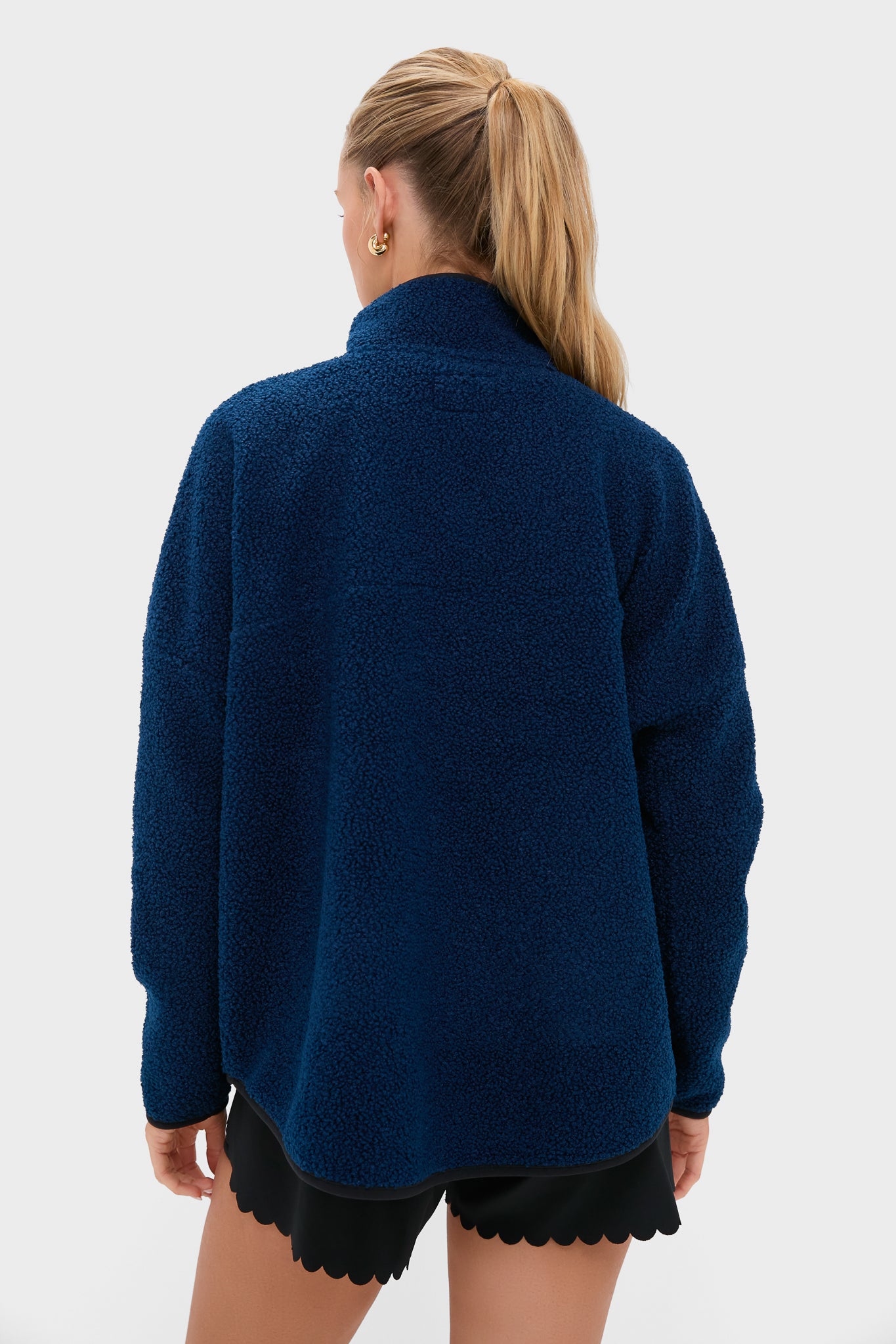 Model in an effortless Navy Fleece Cady Quarter Zip, showcasing a classic sherpa-style with a stand collar and quarter zip, epitomizing high-end, fun style.