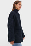 Young woman models the Navy Boucle Barrett Coat, a classic, high-end textured knit with patch pockets, over a matching turtleneck and jeans for an effortless, fun look.
