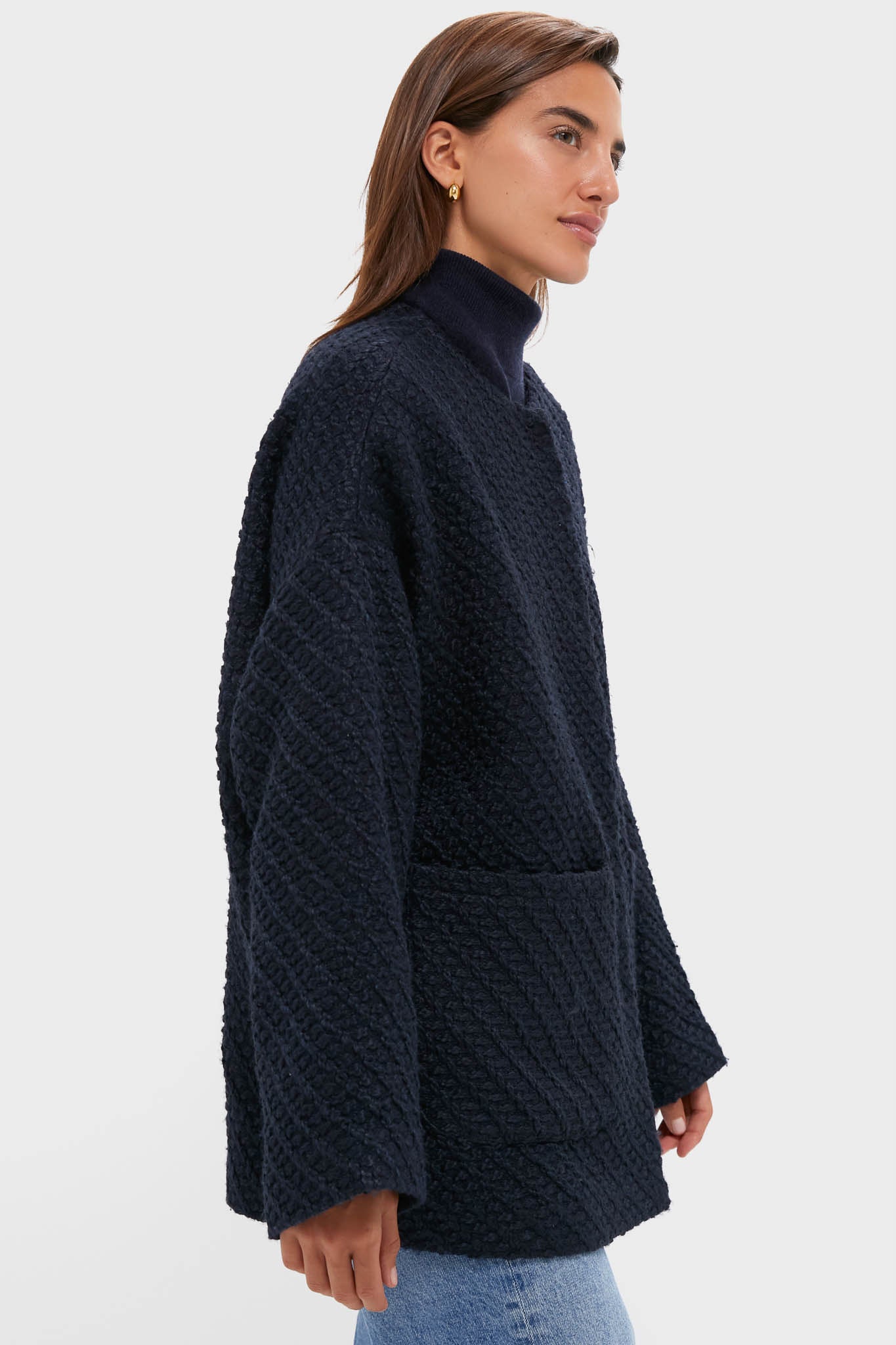 Young woman models the Navy Boucle Barrett Coat, a classic, high-end textured knit with patch pockets, over a matching turtleneck and jeans for an effortless, fun look.