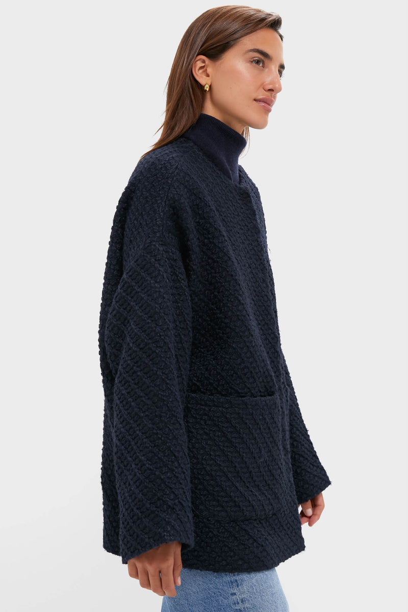 Young woman models the Navy Boucle Barrett Coat, a classic, high-end textured knit with patch pockets, over a matching turtleneck and jeans for an effortless, fun look.