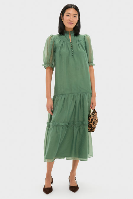 Model in a classic, soft-green, tiered dress, holding a leopard-print bag, wearing Berry Clover Teardrop Earrings - Gold, embodying effortless, high-end style with fun elegance.