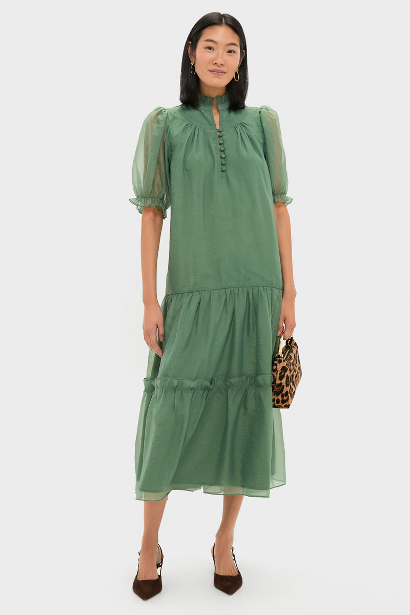 Model in a classic, soft-green, tiered dress, holding a leopard-print bag, wearing Berry Clover Teardrop Earrings - Gold, embodying effortless, high-end style with fun elegance.