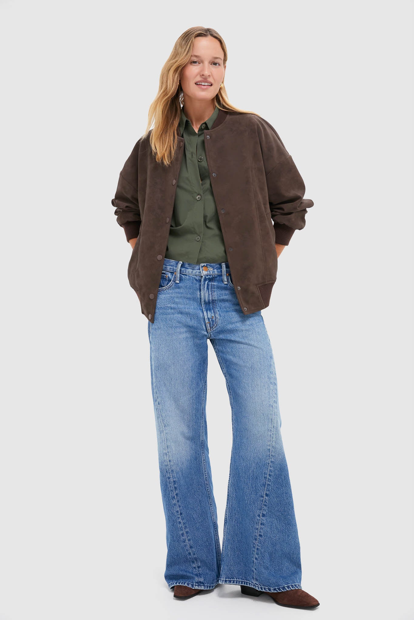 Woman models the Chocolate Alfie Jacket, a classic, high-end faux leather bomber with ribbed trims and snap placket, exuding effortless, fun style.