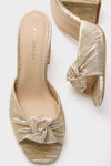 Gold Pleated Blake Heels, classic slip-on mules with a low block heel, feature knotted metallic gold pleated fabric, combining effortless elegance with high-end style for a fun, confident look.