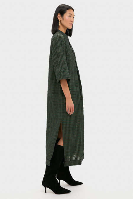 Model wearing the classic, high-end Metallic Green Plaid Indy Maxi Dress, effortlessly styled with black suede boots and gold earrings, showcasing a fun, relaxed elegance.