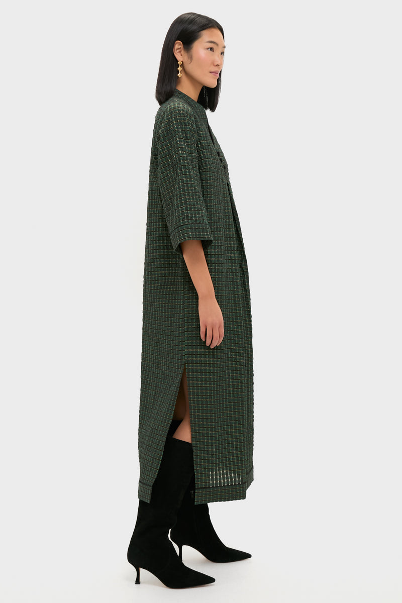 Model wearing the classic, high-end Metallic Green Plaid Indy Maxi Dress, effortlessly styled with black suede boots and gold earrings, showcasing a fun, relaxed elegance.