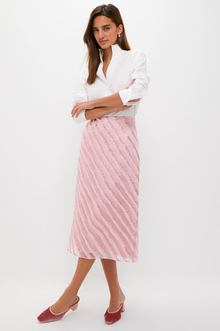 Woman models the classic, high-end Soft Pink Shimmer Stripes Milan Midi Skirt, styled effortlessly with a white blouse, embodying fun sophistication.