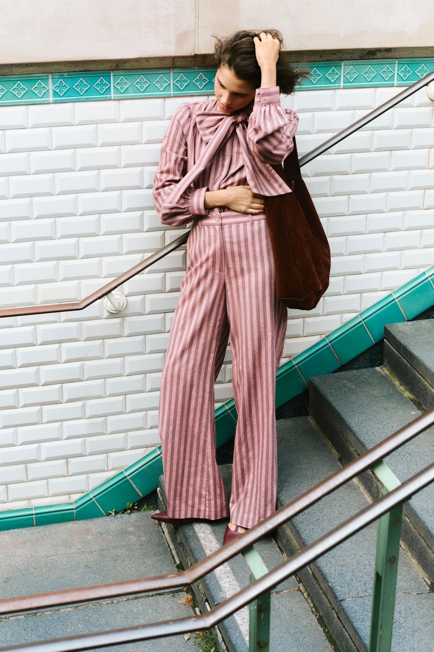 Young woman effortlessly poses with the classic Chocolate Soft M Hobo tote, showcasing its high-end, versatile design with flat handles and graphic silhouette.