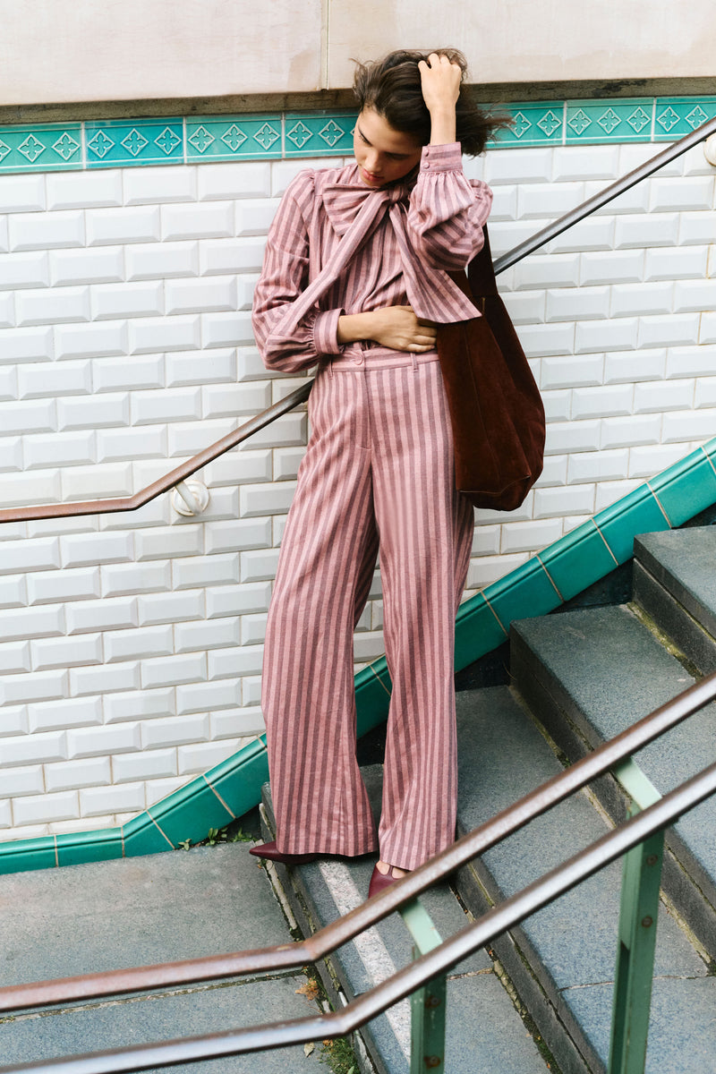 Young woman effortlessly poses with the classic Chocolate Soft M Hobo tote, showcasing its high-end, versatile design with flat handles and graphic silhouette.