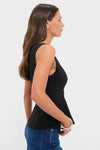 Young woman models the Black Sleeveless Decker Peplum Top, showcasing its classic and effortless design with a scoop neckline and peplum silhouette, perfect for high-end, fun occasions.