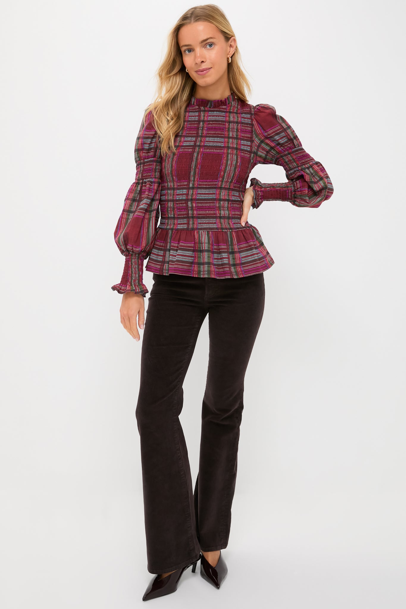 Model wearing Mocha Kinsley Mid Rise Ultra Flare Cord pants paired with a plaid blouse, showcasing a classic, effortless, and high-end style with dramatic, fun flares.