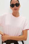 Person wearing classic Pink Short Sleeve Performance Jersey Ryan Boyfriend Tee, exuding effortless style with sunglasses and sweater tied at waist, embodying fun, high-end Tuckernuck spirit.
