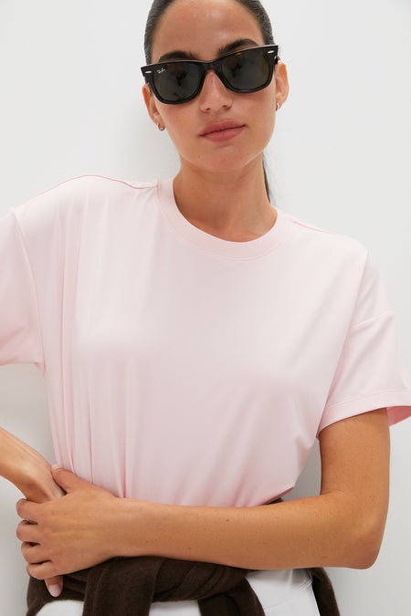 Person wearing classic Pink Short Sleeve Performance Jersey Ryan Boyfriend Tee, exuding effortless style with sunglasses and sweater tied at waist, embodying fun, high-end Tuckernuck spirit.