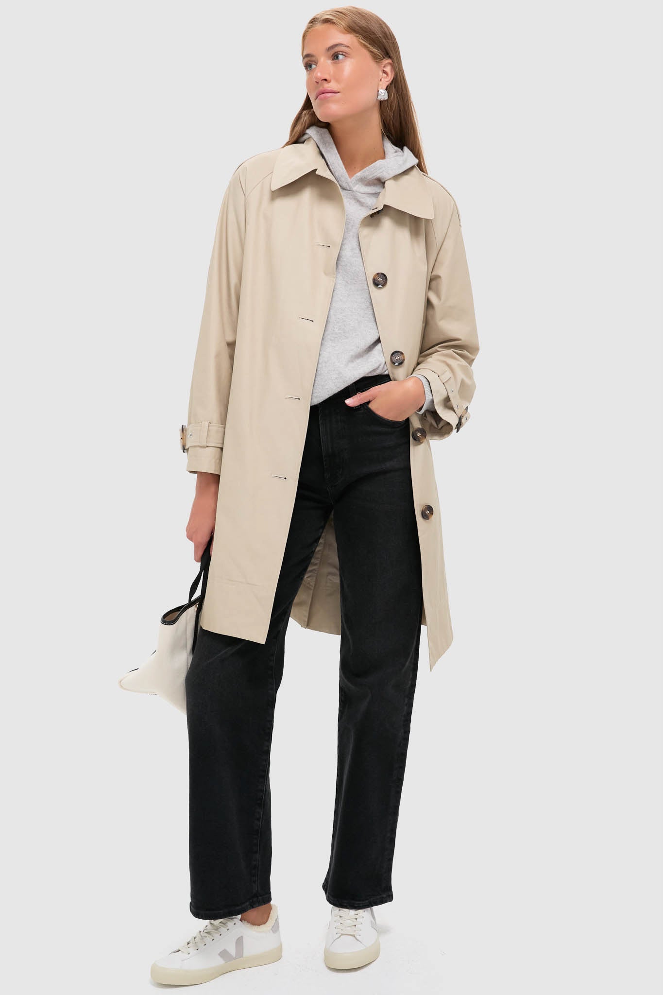 Model in beige trench coat, showcasing VEJA's Extra White Light Grey Winter Campo Sneakers, embodying a classic, effortless style with high-end comfort and fun, chic details.