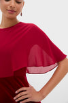 Model showcases the Cranberry Velvet Chiffon Mixed Media Cape Leah Dress, featuring an effortless, classic cape-style chiffon overlay and high-end velvet bodice, exuding fun and confidence.