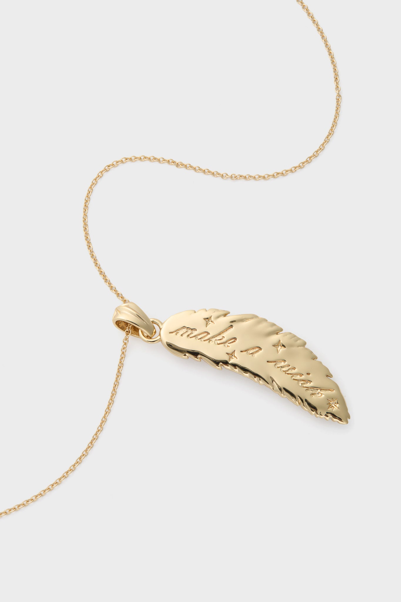 Gold Lucky Feather Pendant: A classic, high-end necklace with a polished feather-shaped pendant engraved with star motifs and make a wish for an effortless, fun style.