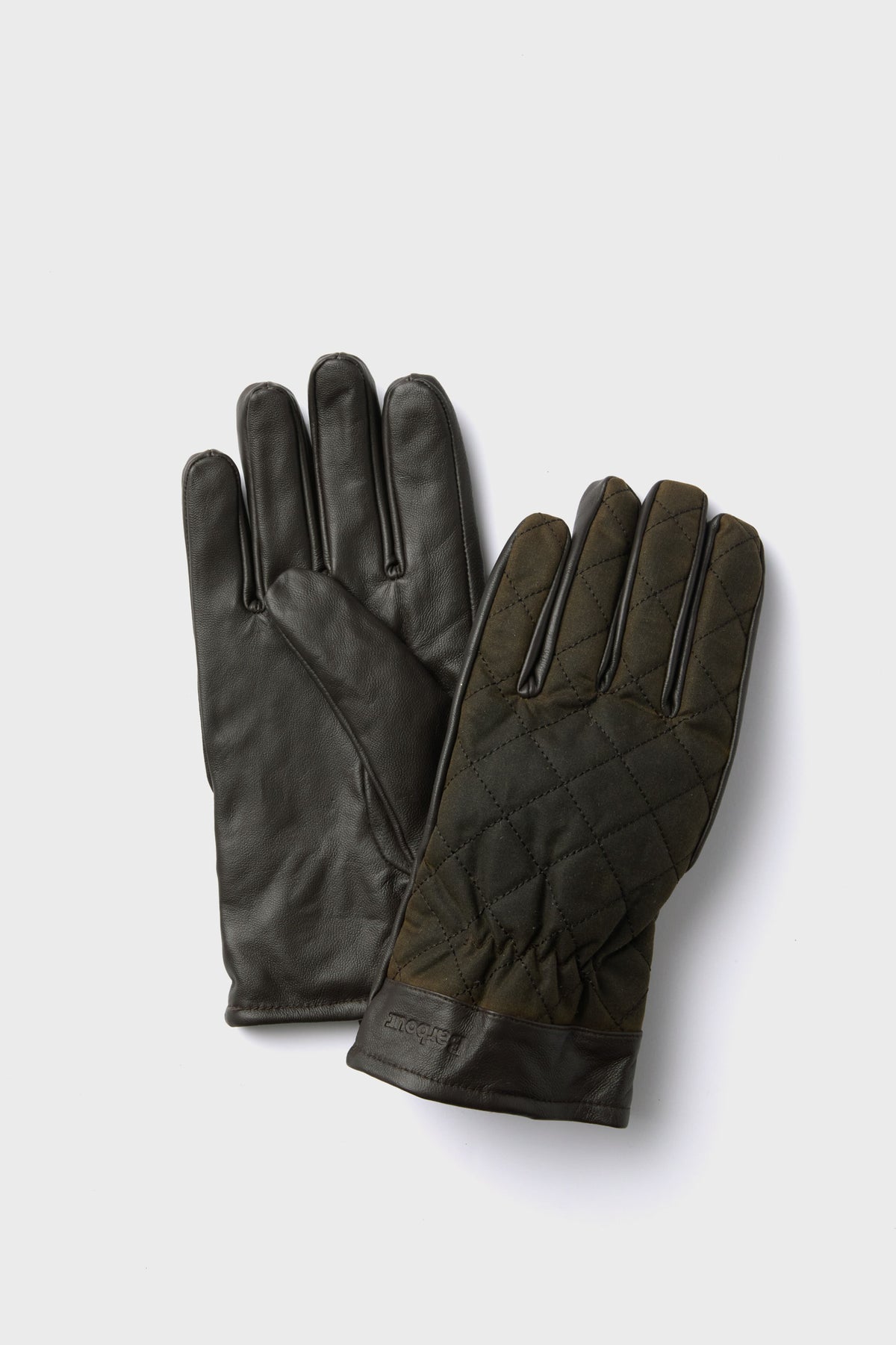 A pair of dark green Barbour gloves made from quilted waxed cotton with nappa leather palms and cuffs.