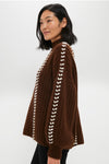 Woman in profile modeling the Brown Mayu Sweater, showcasing its classic high neck, chic hand-embroidered details, and effortless balloon sleeves, embodying high-end, fun style.
