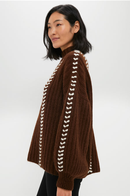 Woman in profile modeling the Brown Mayu Sweater, showcasing its classic high neck, chic hand-embroidered details, and effortless balloon sleeves, embodying high-end, fun style.