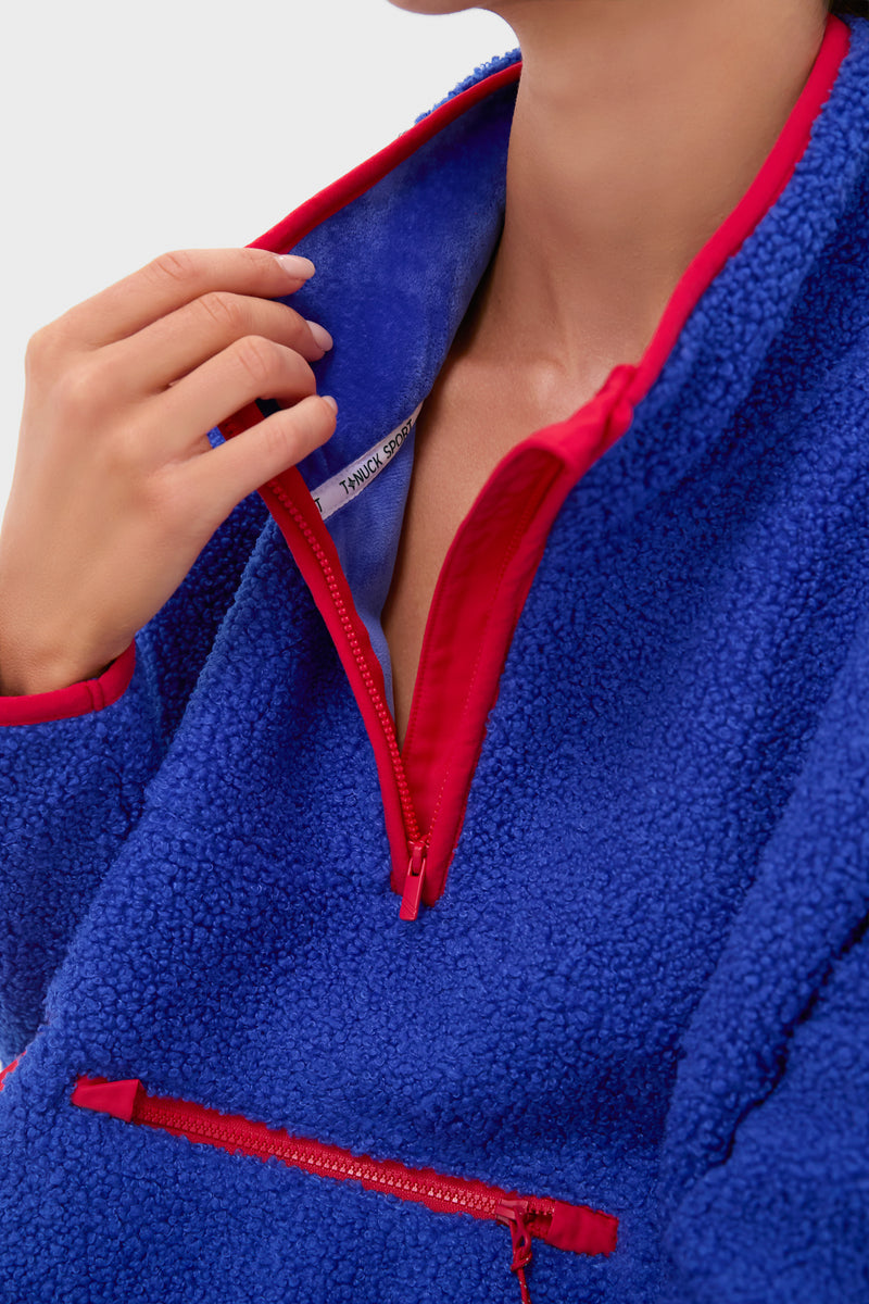 Blue and Red Fleece Cady Quarter Zip features a classic sherpa design with an effortless bright red zipper trim, showcasing a fun, high-end style with a chest zip pocket.