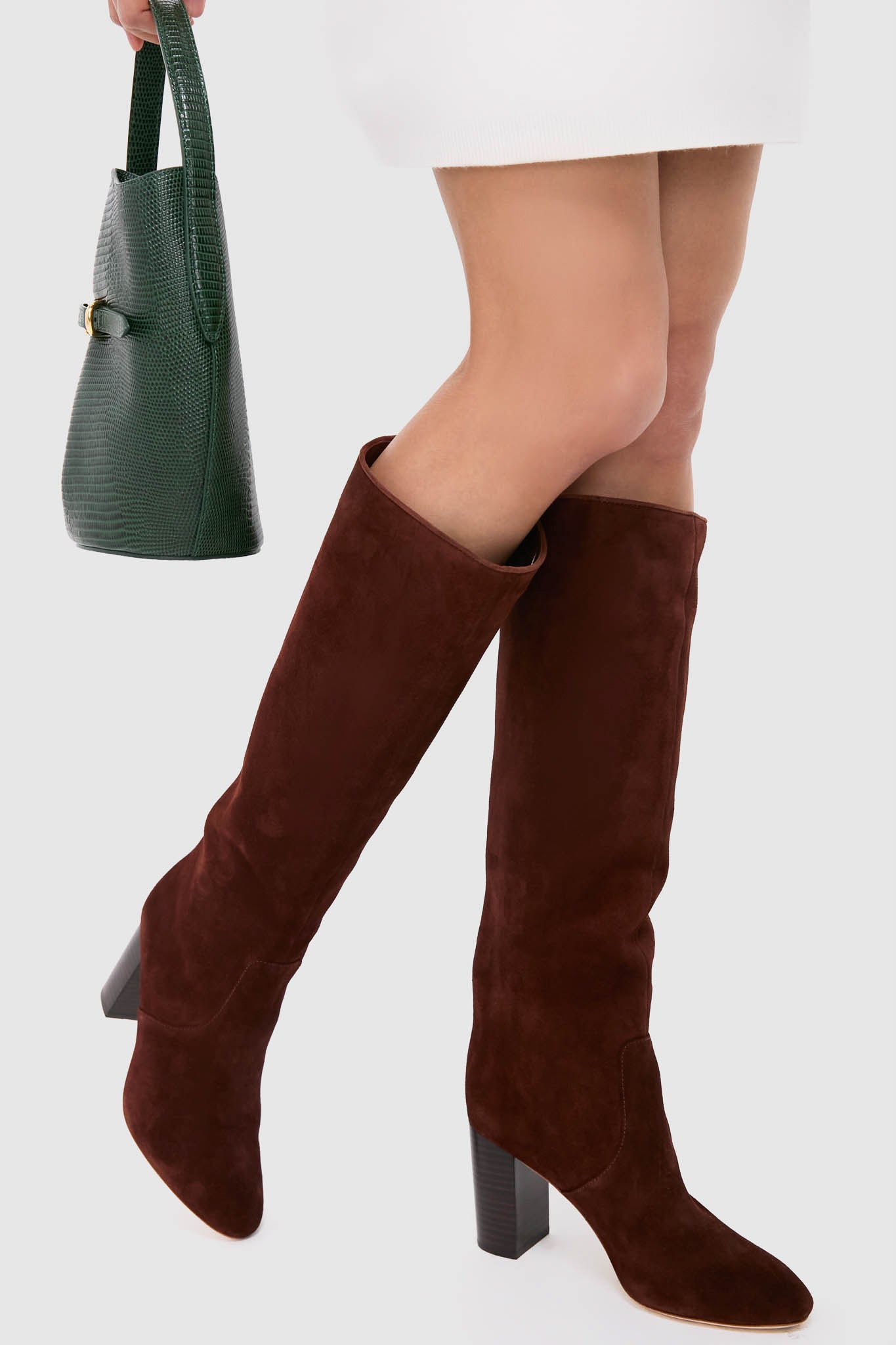 Model wears Espresso Suede Goldy Boots, classic knee-high suede with chunky heel, embodying effortless style. Paired with chic croc-embossed tote, perfect for a fun, high-end look.