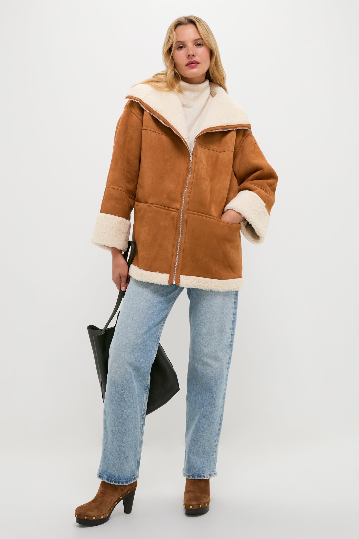 Model wearing a classic, high-end autumn ensemble with a caramel suede jacket and blue jeans, effortlessly accessorized with the Seaweed Everyday Cabas tote for a fun, stylish look.