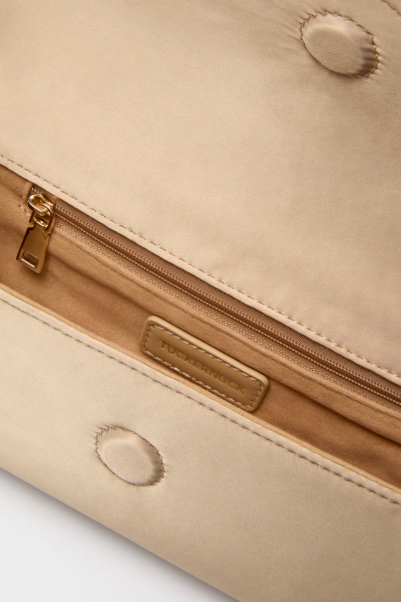 Champagne Satin Gabrielle Clutch interior with gold-tone zippered pocket, branded leather patch, and magnetic snaps. A classic, high-end accessory for effortless, fun evenings.