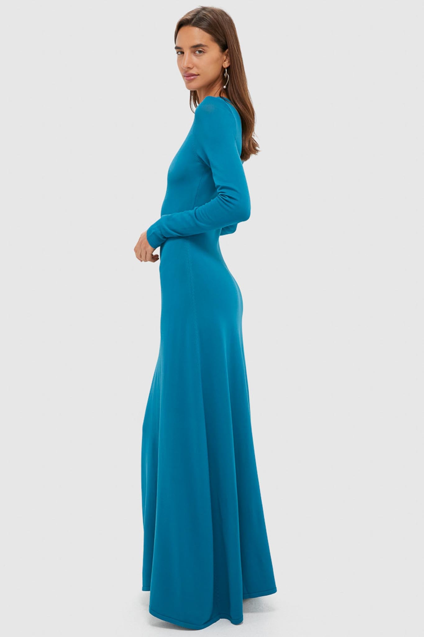 Fashion model in profile wearing the classic Nocturnal Blue Dora Long Sleeve Maxi Dress, showcasing its effortless, high-end style with a flattering A-line silhouette.