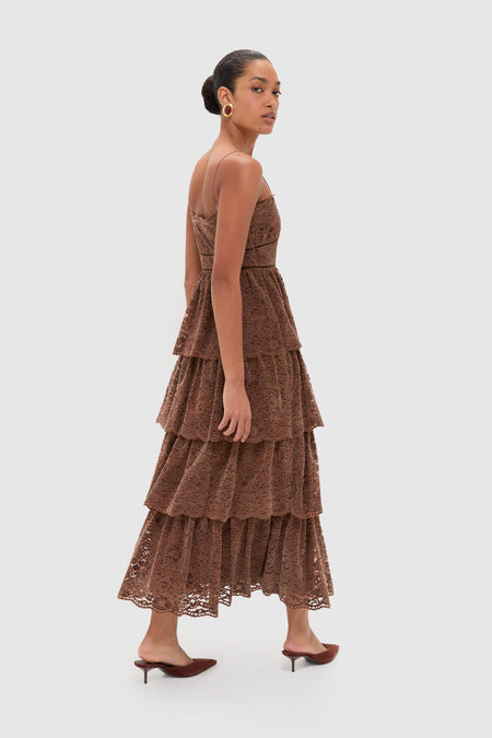 Fashion model in a classic, effortless Sepia Lace Leina Midi Dress with tiered velvet lace, fitted bodice, and adjustable straps, styled with gold earrings and matching mules.
