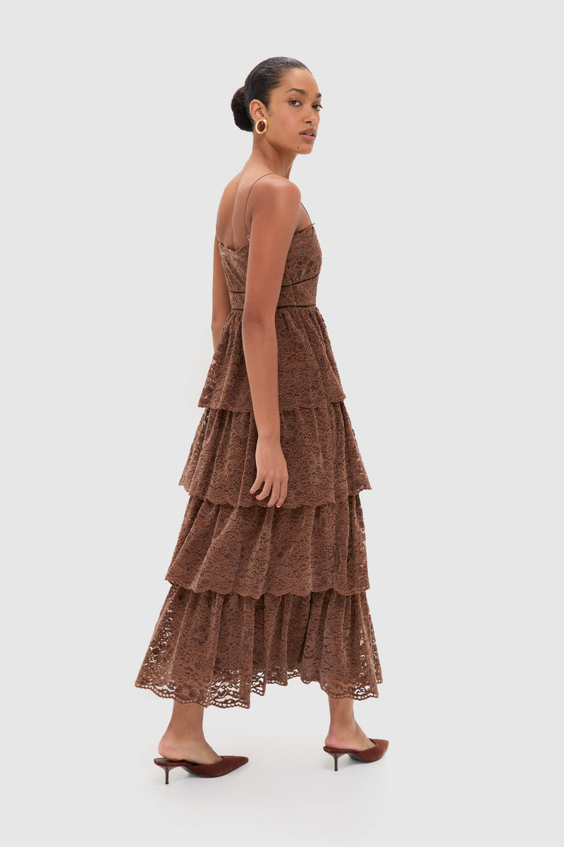 Fashion model in a classic, effortless Sepia Lace Leina Midi Dress with tiered velvet lace, fitted bodice, and adjustable straps, styled with gold earrings and matching mules.