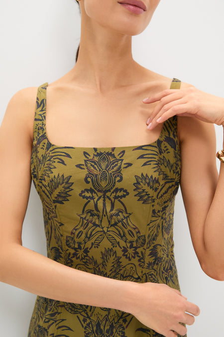 Model wearing the Olive Flora Natali Dress, featuring classic wide straps and a square neckline, adorned with a high-end, effortless floral pattern, accessorized with a gold bangle.