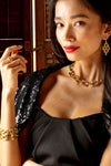 Woman in a strapless black dress showcases the Pathway Petite Link Bracelet in Gold, featuring classic interlocked links, exuding effortless elegance and high-end style.