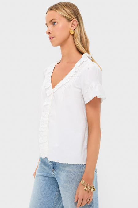 Model wearing the Vintage White Ezra Blouse with eyelet embroidery, scalloped trims, and short flutter sleeves, styled effortlessly with jeans and gold accessories for a classic, high-end look.