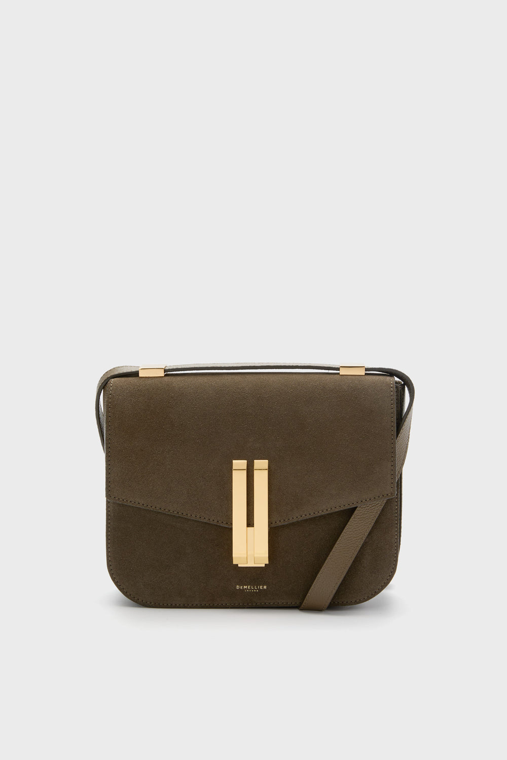 The Demellier Olive Suede Vancouver Bag is a brown rectangular crossbody with gold hardware and a front flap closure, handcrafted in leather for everyday elegance.