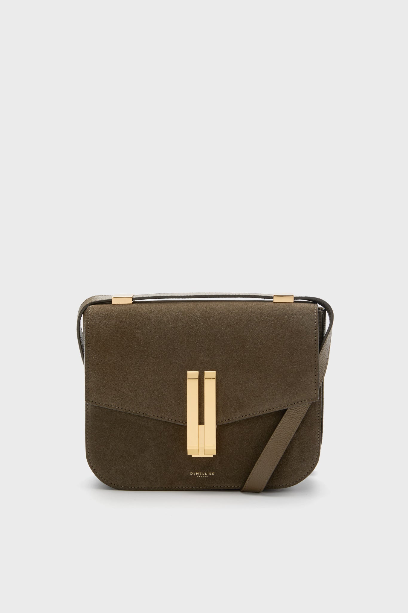 The Demellier Olive Suede Vancouver Bag is a brown rectangular crossbody with gold hardware and a front flap closure, handcrafted in leather for everyday elegance.